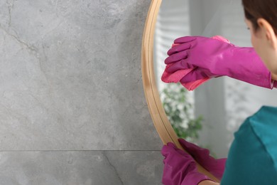 Photo of Woman cleaning mirror with rag indoors, closeup. Space for text