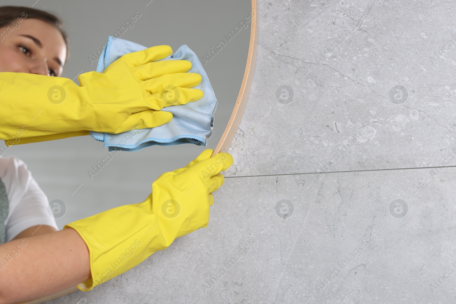 Photo of Woman cleaning mirror with rag indoors, closeup. Space for text