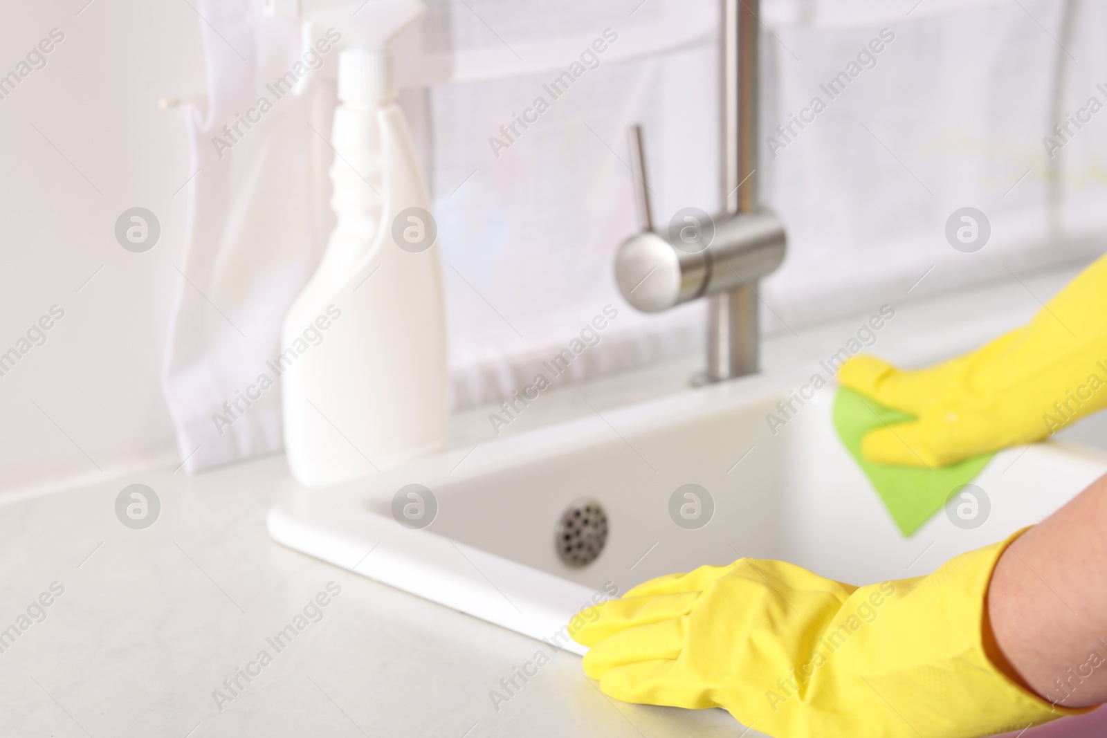 Photo of Woman cleaning sink with rag in kitchen, closeup