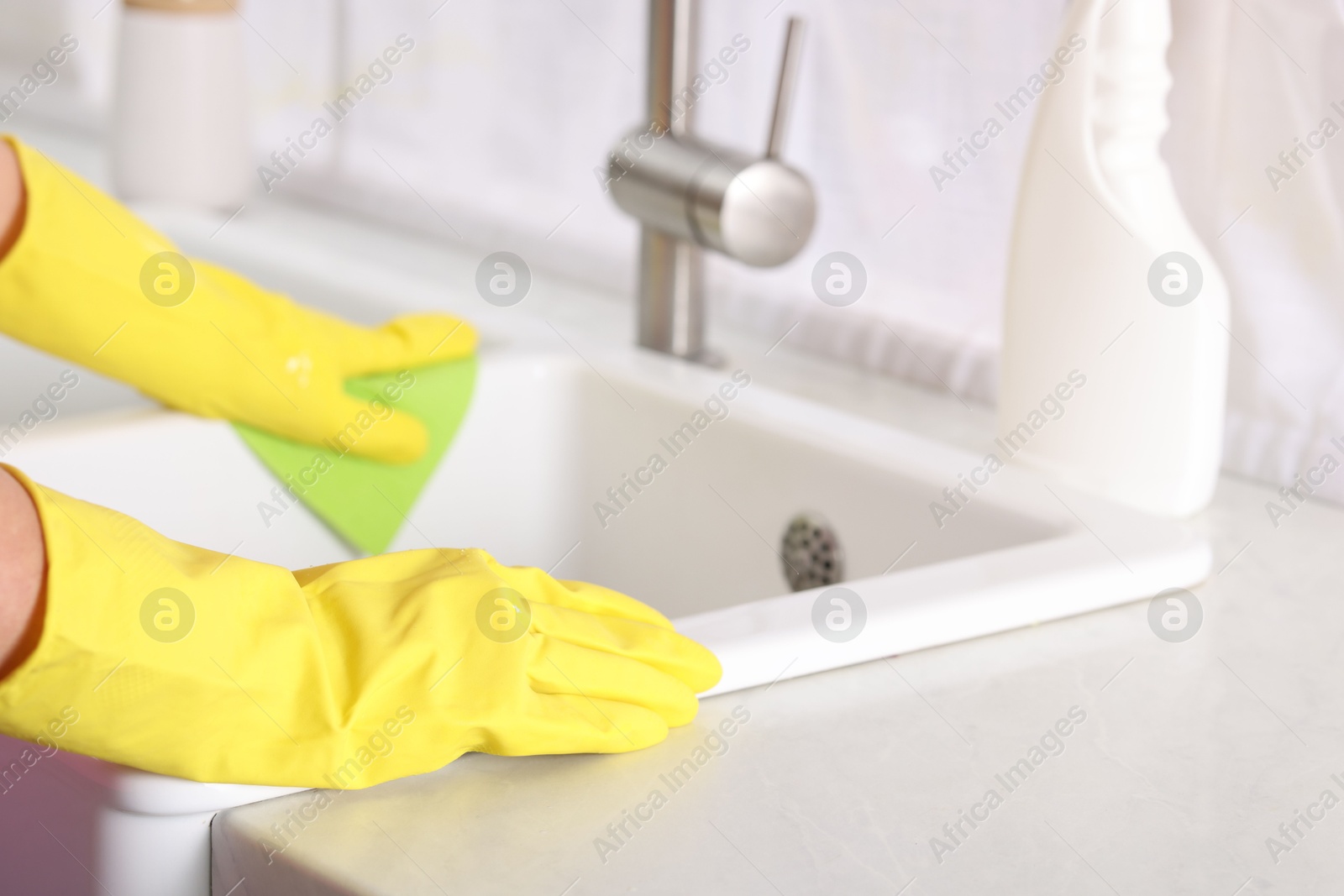 Photo of Woman cleaning sink with rag in kitchen, closeup