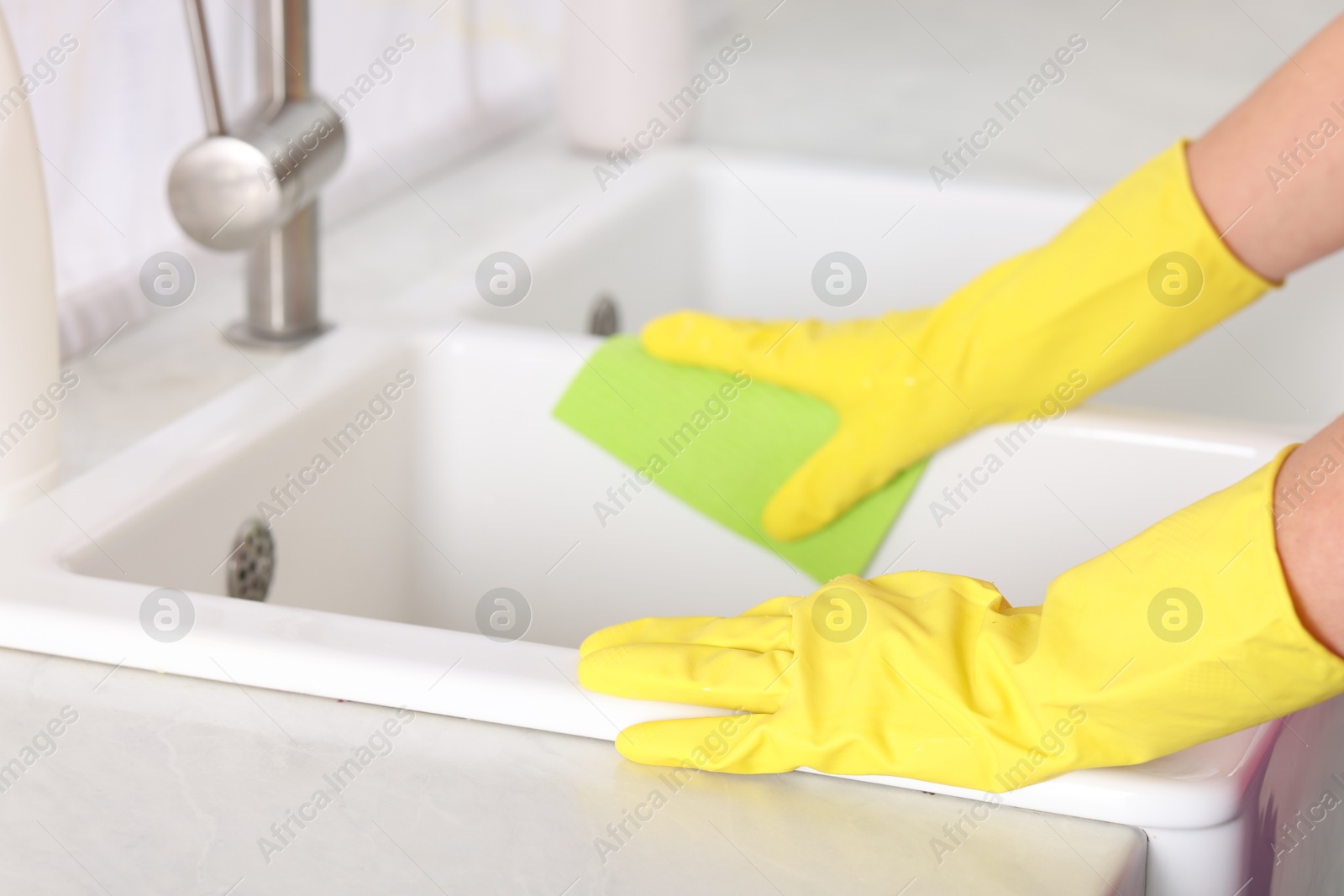 Photo of Woman cleaning sink with rag in kitchen, closeup. Space for text