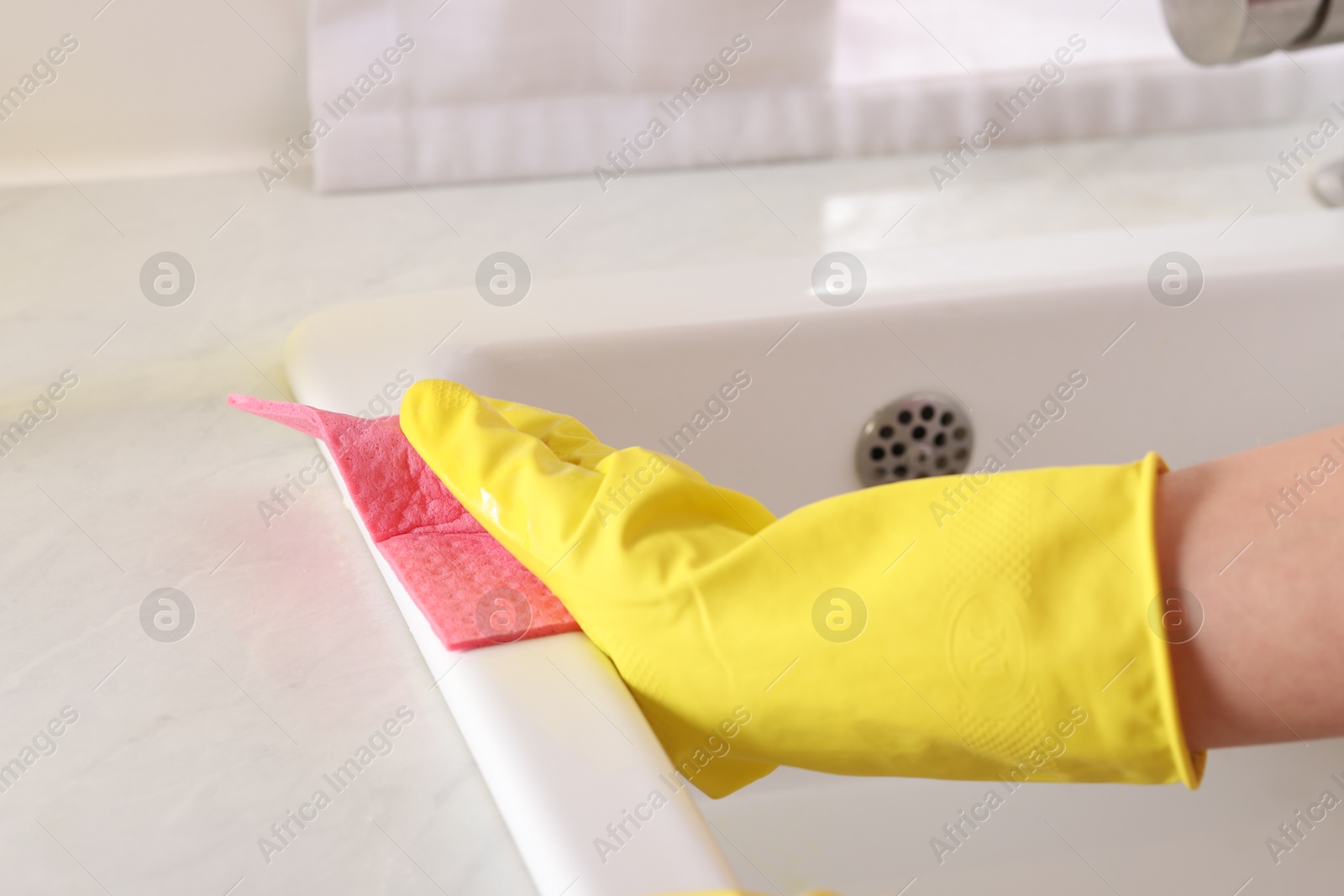 Photo of Woman cleaning sink with rag in kitchen, closeup