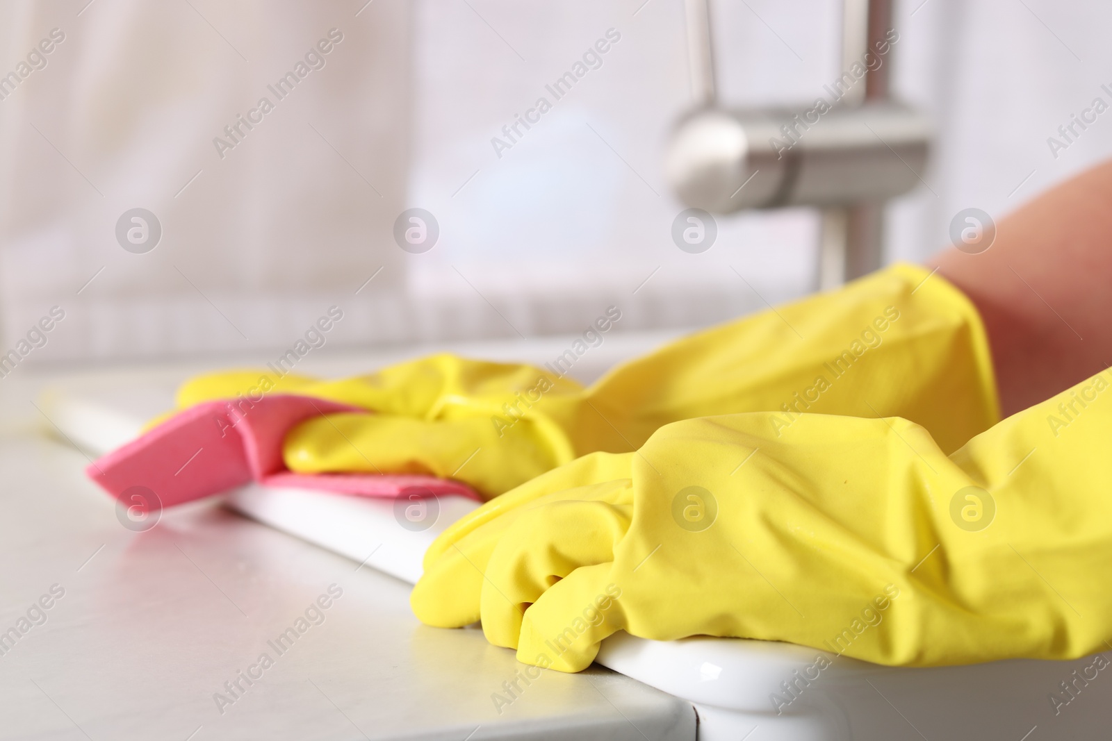 Photo of Woman cleaning sink with rag in kitchen, closeup