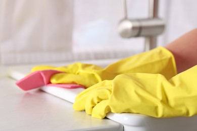 Photo of Woman cleaning sink with rag in kitchen, closeup