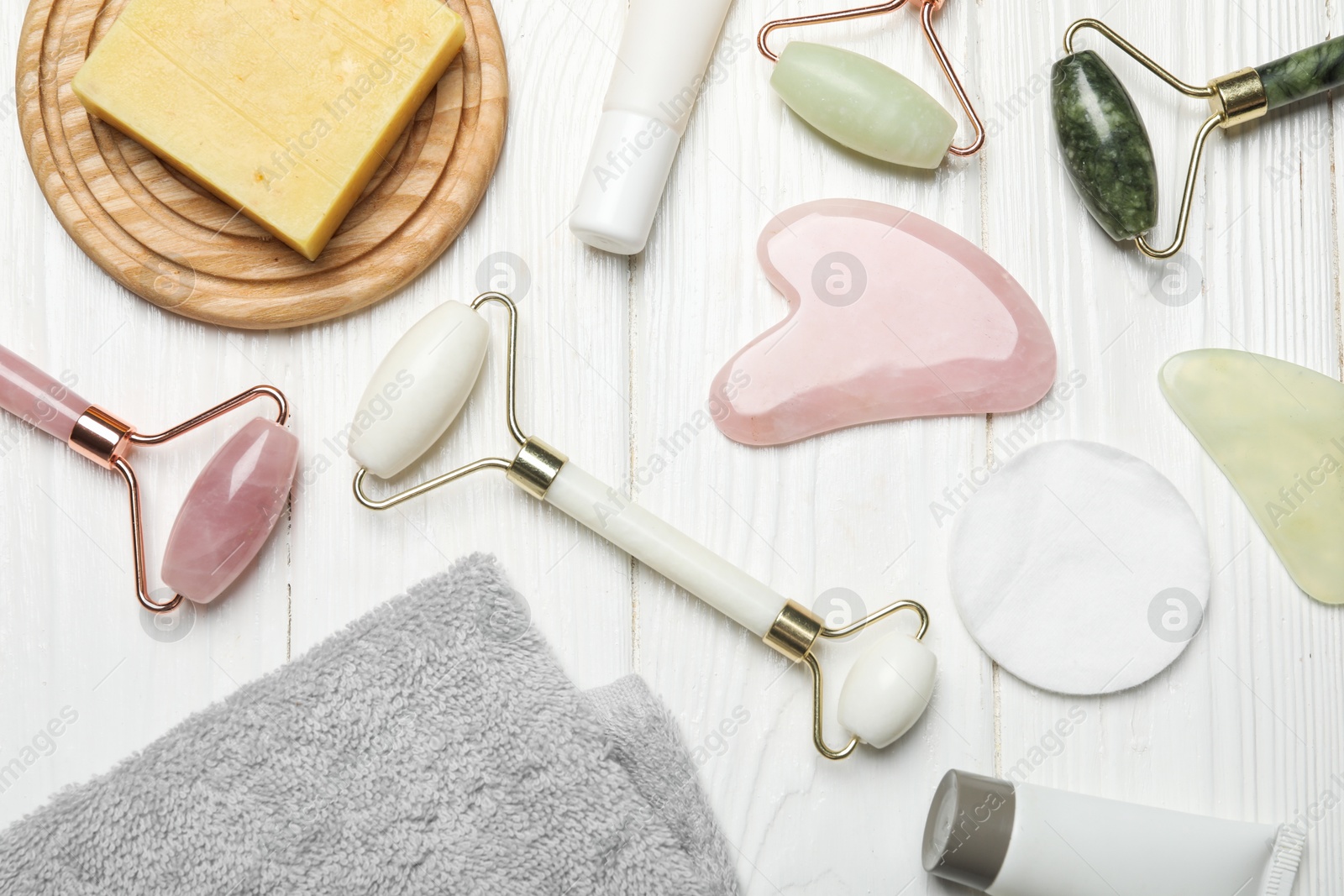 Photo of Flat lay composition with face rollers and gua sha tools on wooden background