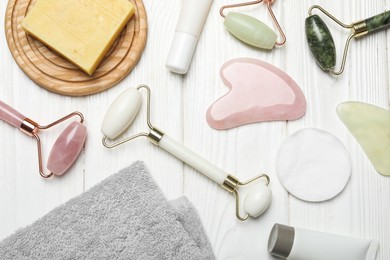 Photo of Flat lay composition with face rollers and gua sha tools on wooden background