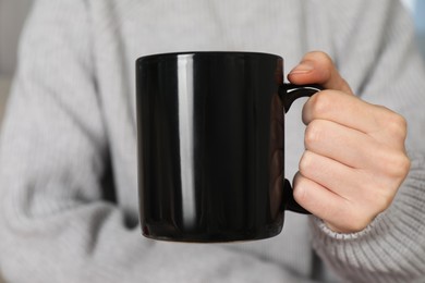 Photo of Woman with black ceramic cup, closeup. Mockup for design