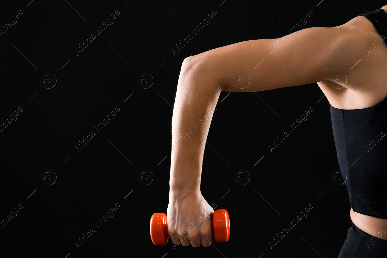 Photo of Woman exercising with dumbbell on black background, closeup. Space for text