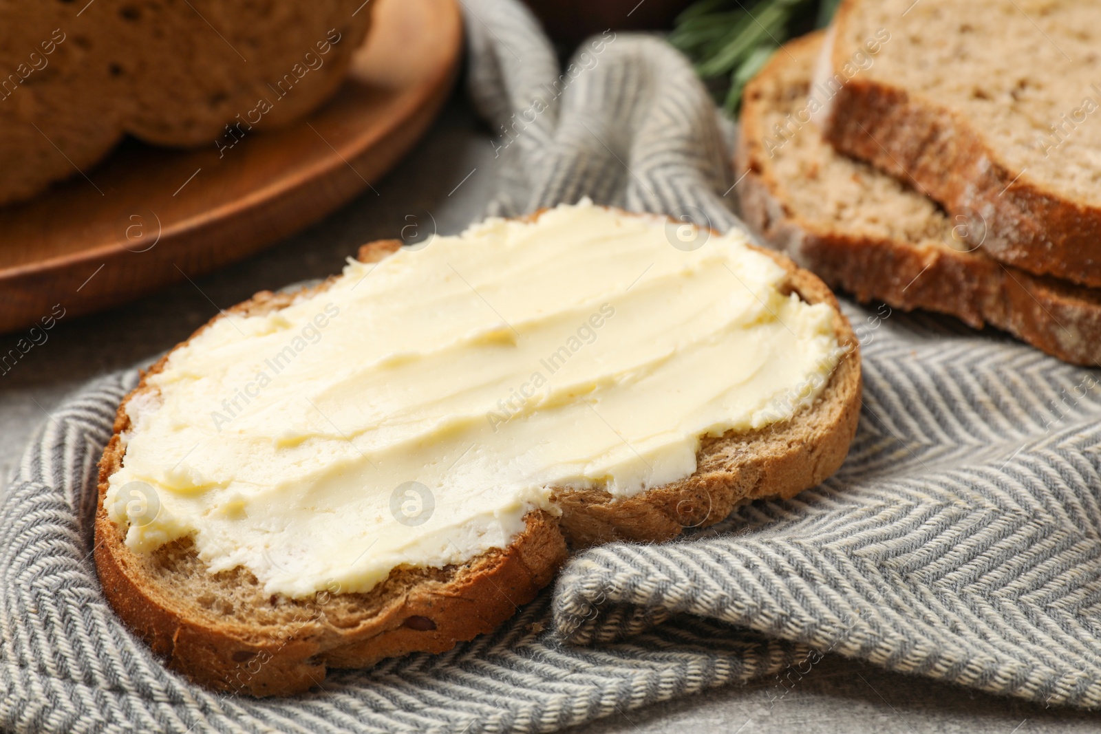 Fresh bread with butter on grey table, closeup Photo of Fresh bread with butter on grey table, closeup
