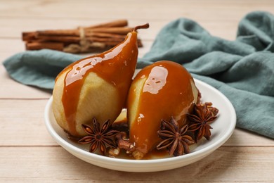 Photo of Delicious pears with caramel sauce and spices on white wooden table, closeup