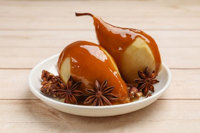 Photo of Delicious pears with caramel sauce and spices on white wooden table, closeup