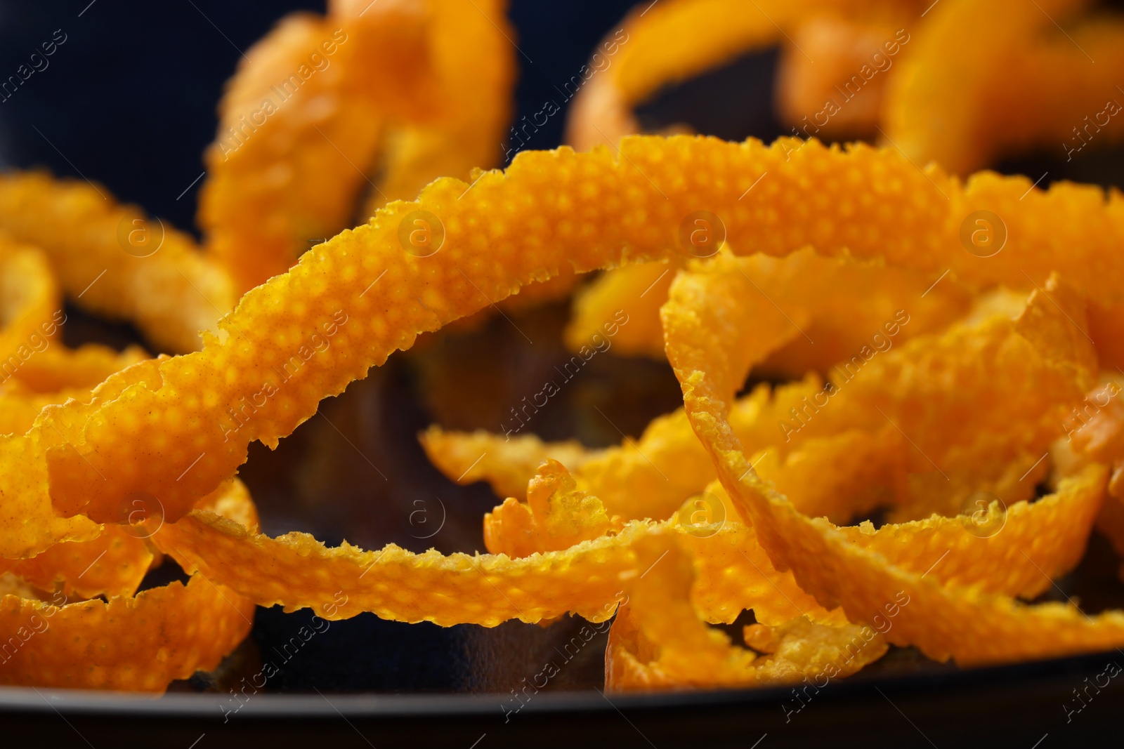 Photo of Pile of fresh orange zest on plate, closeup