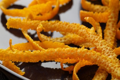 Photo of Pile of fresh orange zest on plate, closeup