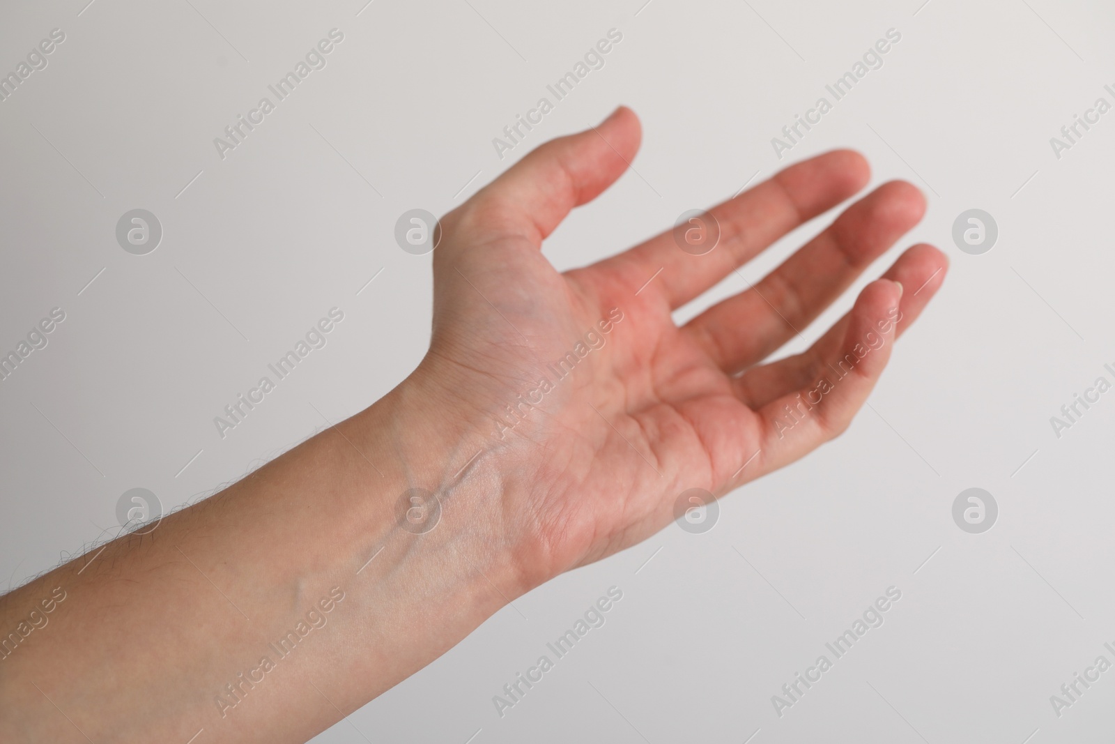 Photo of Woman with visible hand veins on light grey background, closeup