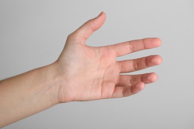 Photo of Woman with visible hand veins on light grey background, closeup