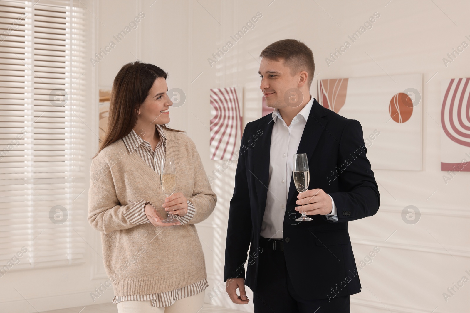 Photo of Couple enjoying art and sparkling wine in gallery