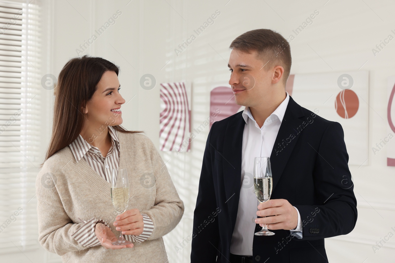 Photo of Couple enjoying art and sparkling wine in gallery