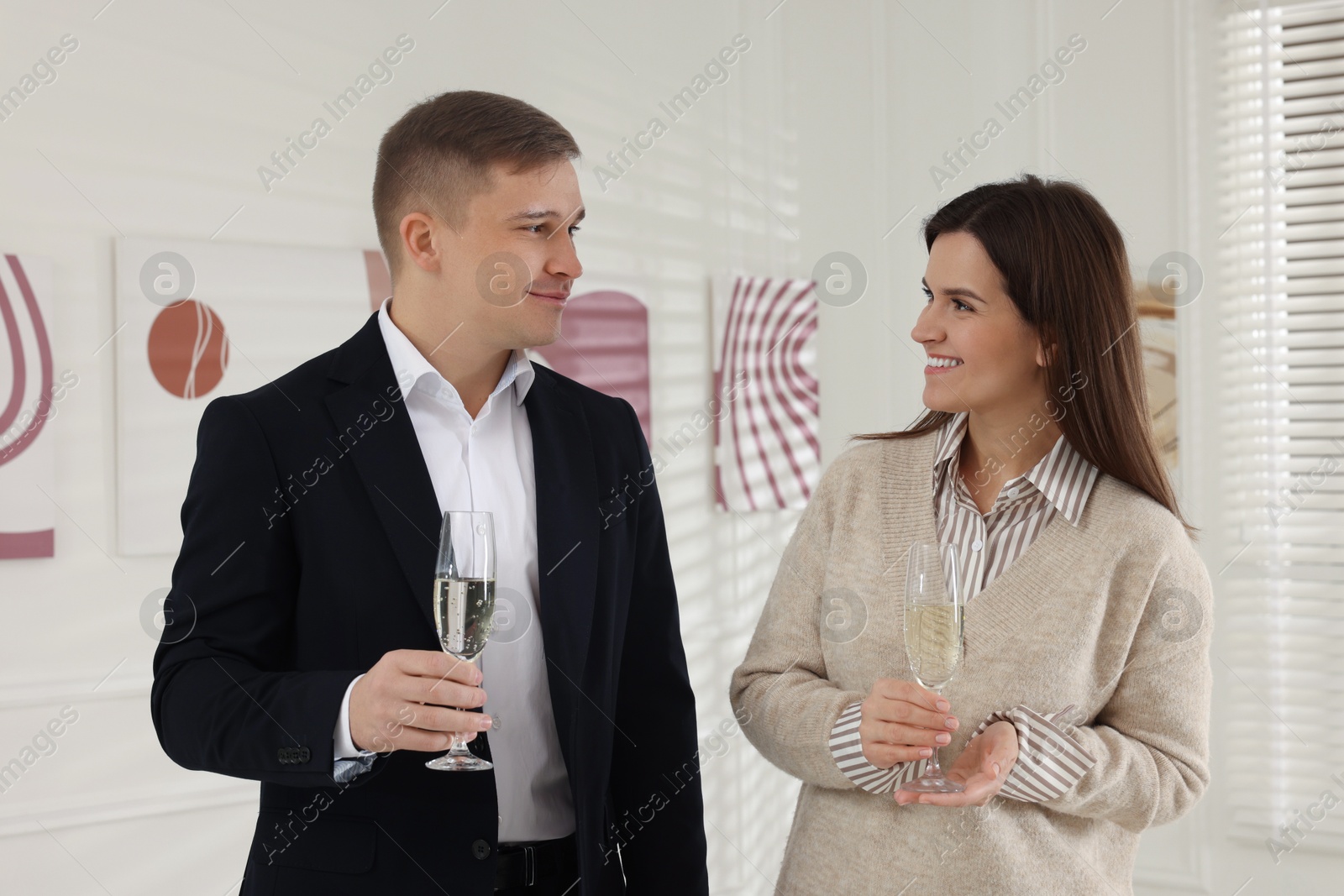 Photo of Couple enjoying art and sparkling wine in gallery