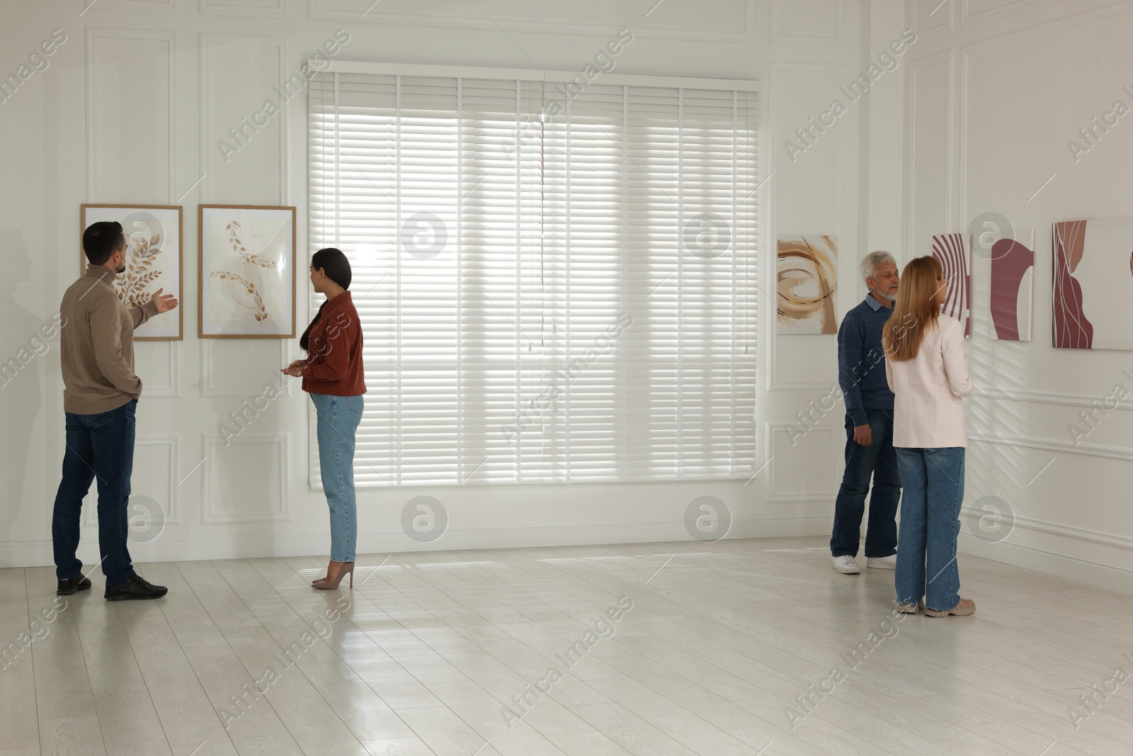 Photo of People studying beautiful art during event in gallery