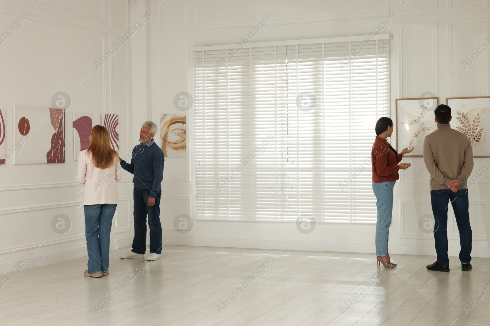 Photo of People studying beautiful art during event in gallery