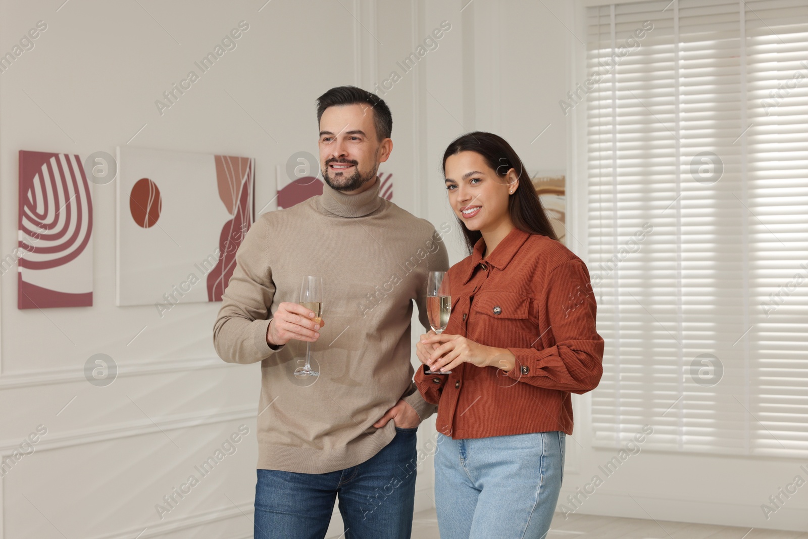 Photo of Couple enjoying art and sparkling wine in gallery