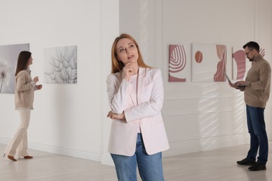 Beautiful woman enjoying art in modern gallery