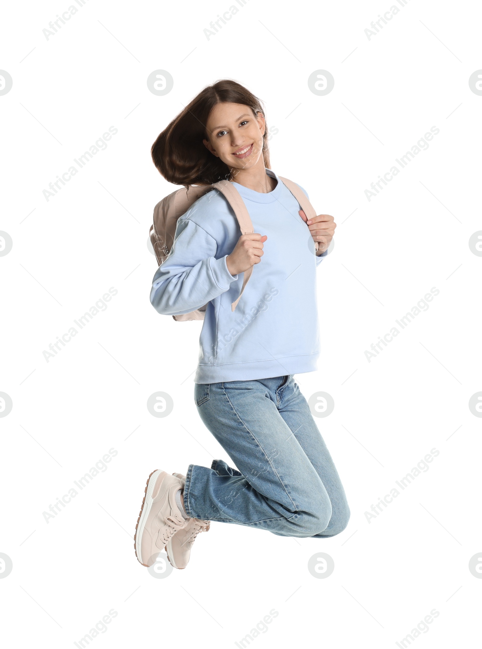 Photo of Smiling teenage girl with backpack jumping on white background