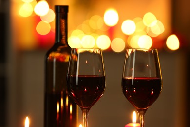 Photo of Glasses of red wine against blurred lights, closeup. Romantic dinner