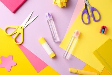 Photo of Flat lay composition with glue, scissors and other stationery on color background