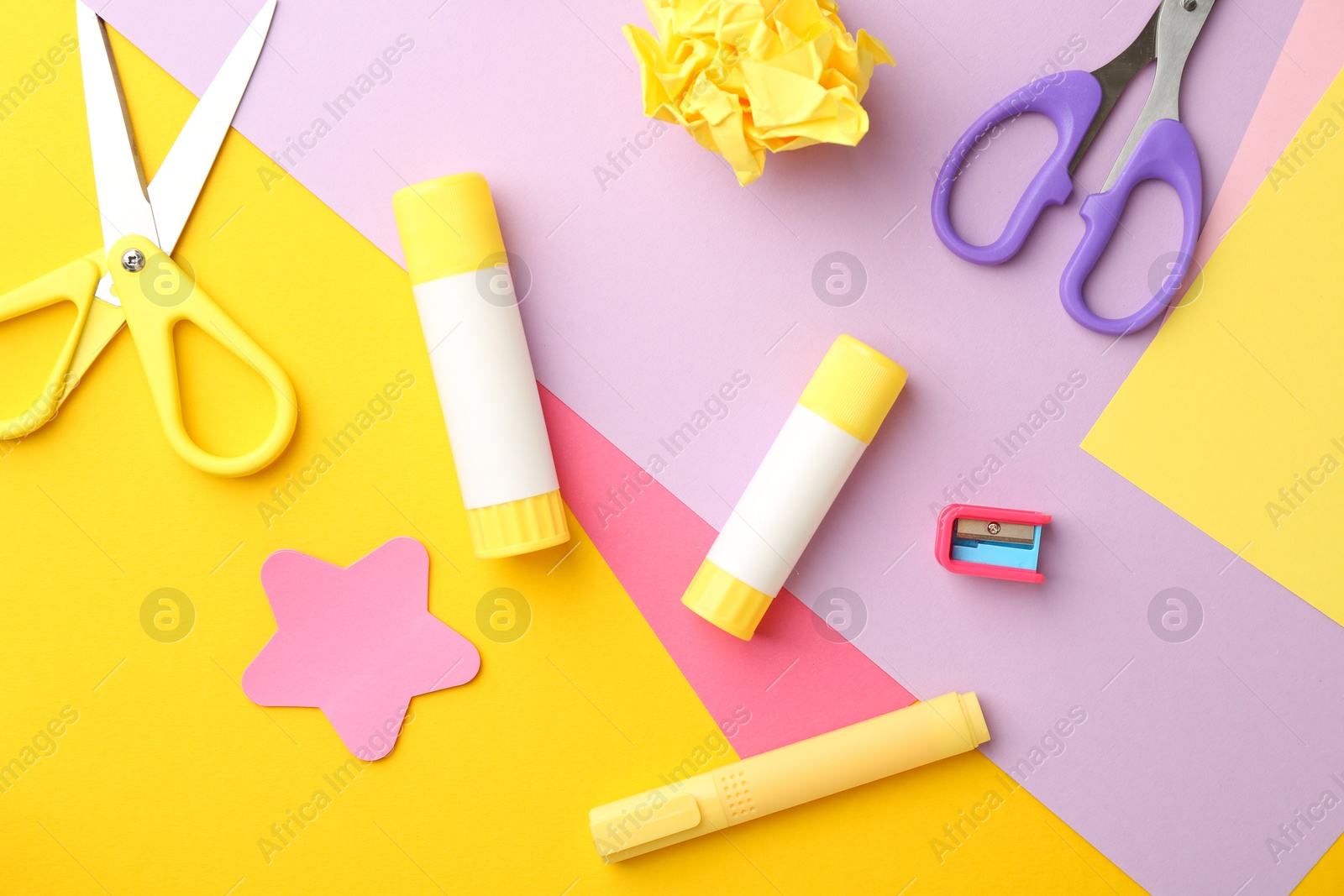 Photo of Flat lay composition with glue, scissors and other stationery on color background