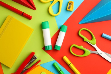 Photo of Flat lay composition with glue, scissors and other stationery on color background