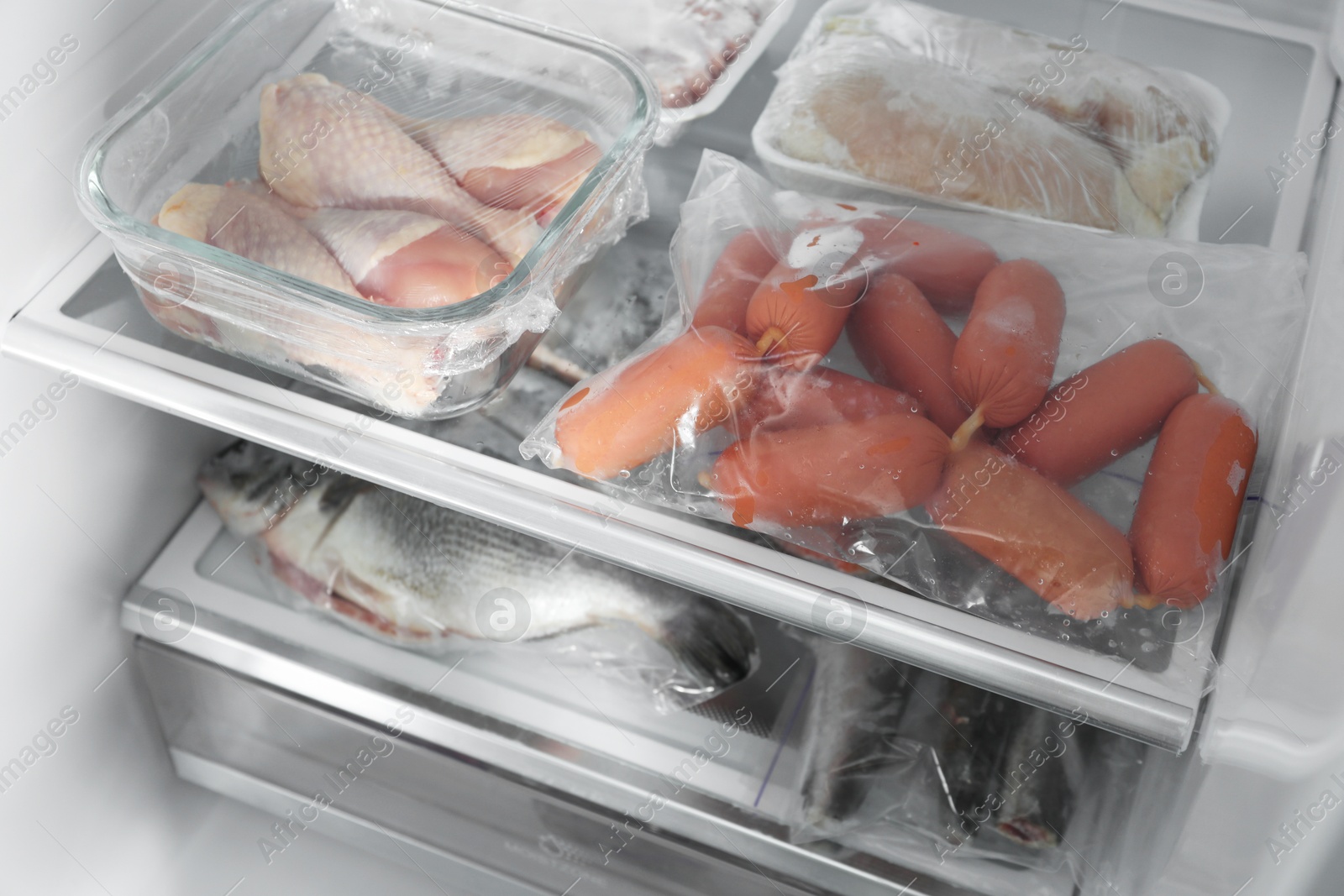 Photo of Different frozen meat and fish products in fridge, closeup