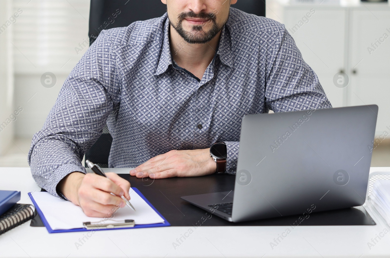 Photo of Banker making notes at table in office, closeup