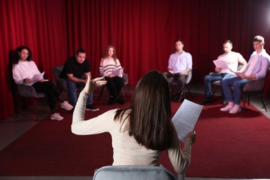 Photo of Professional actors with their scripts rehearsing in theatre