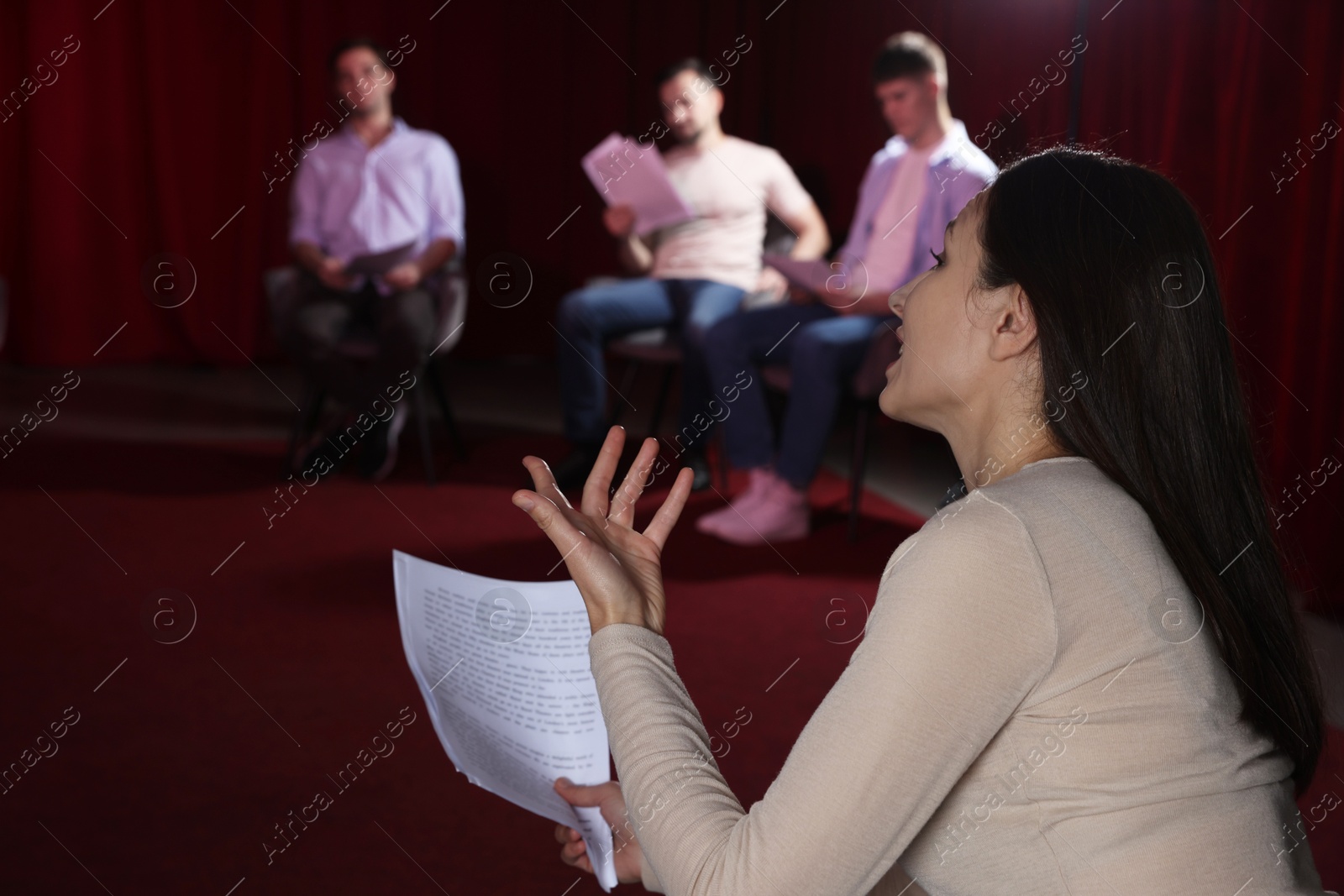 Photo of Professional actors with their scripts rehearsing in theatre