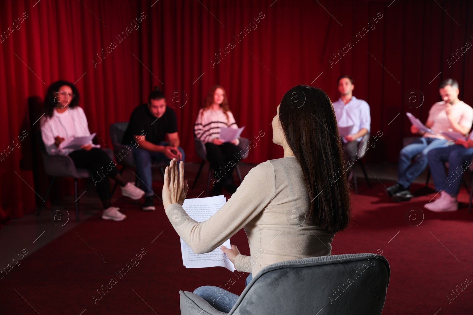 Photo of Professional actors with their scripts rehearsing in theatre