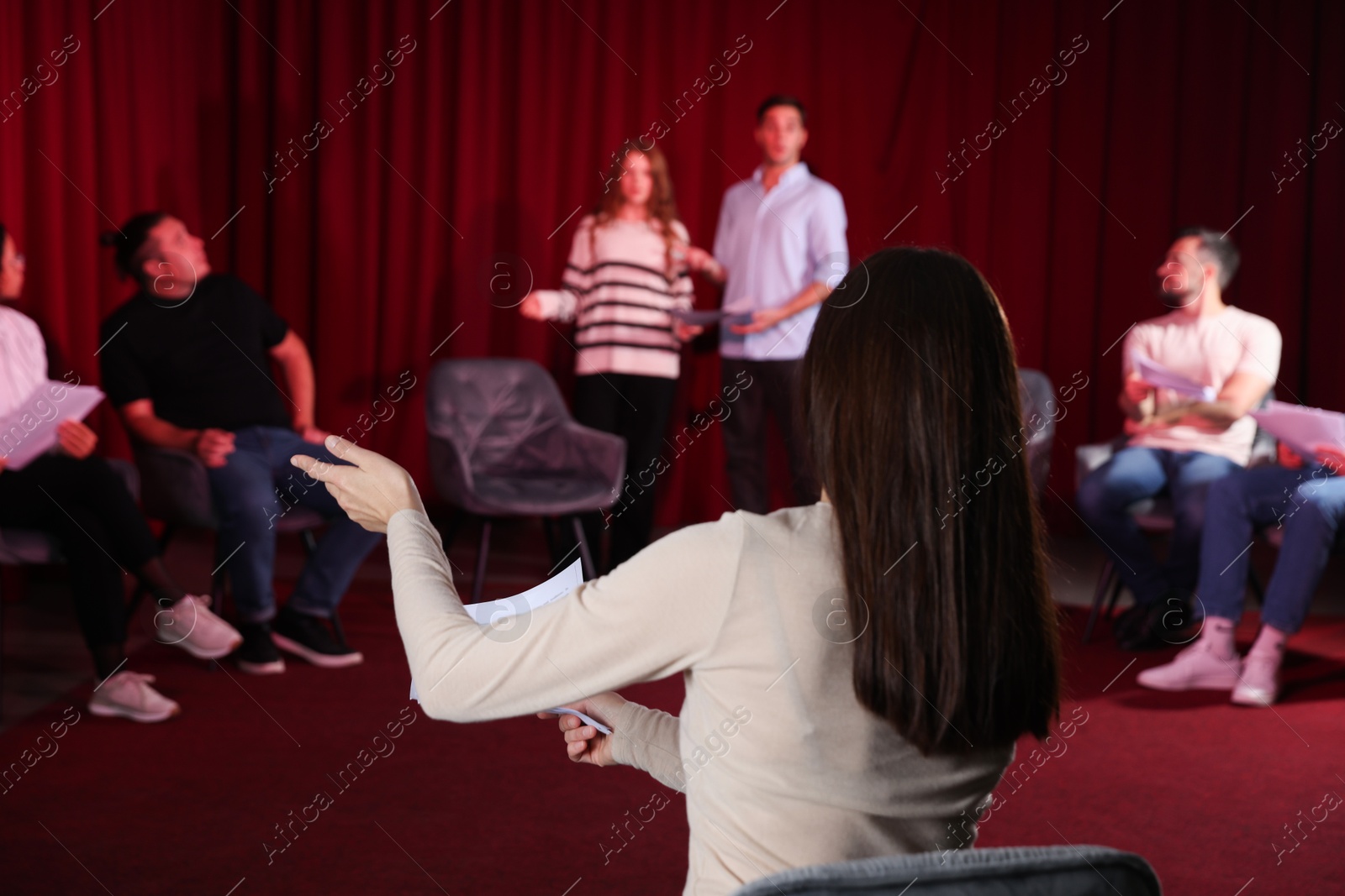 Photo of Professional actors with their scripts rehearsing in theatre