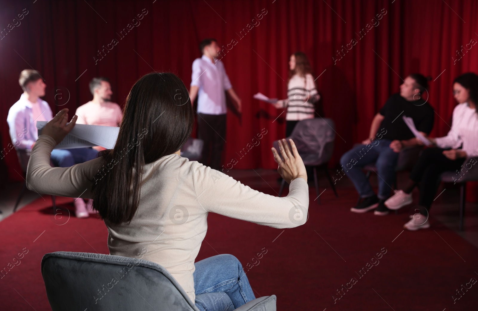 Photo of Professional actors with their scripts rehearsing in theatre