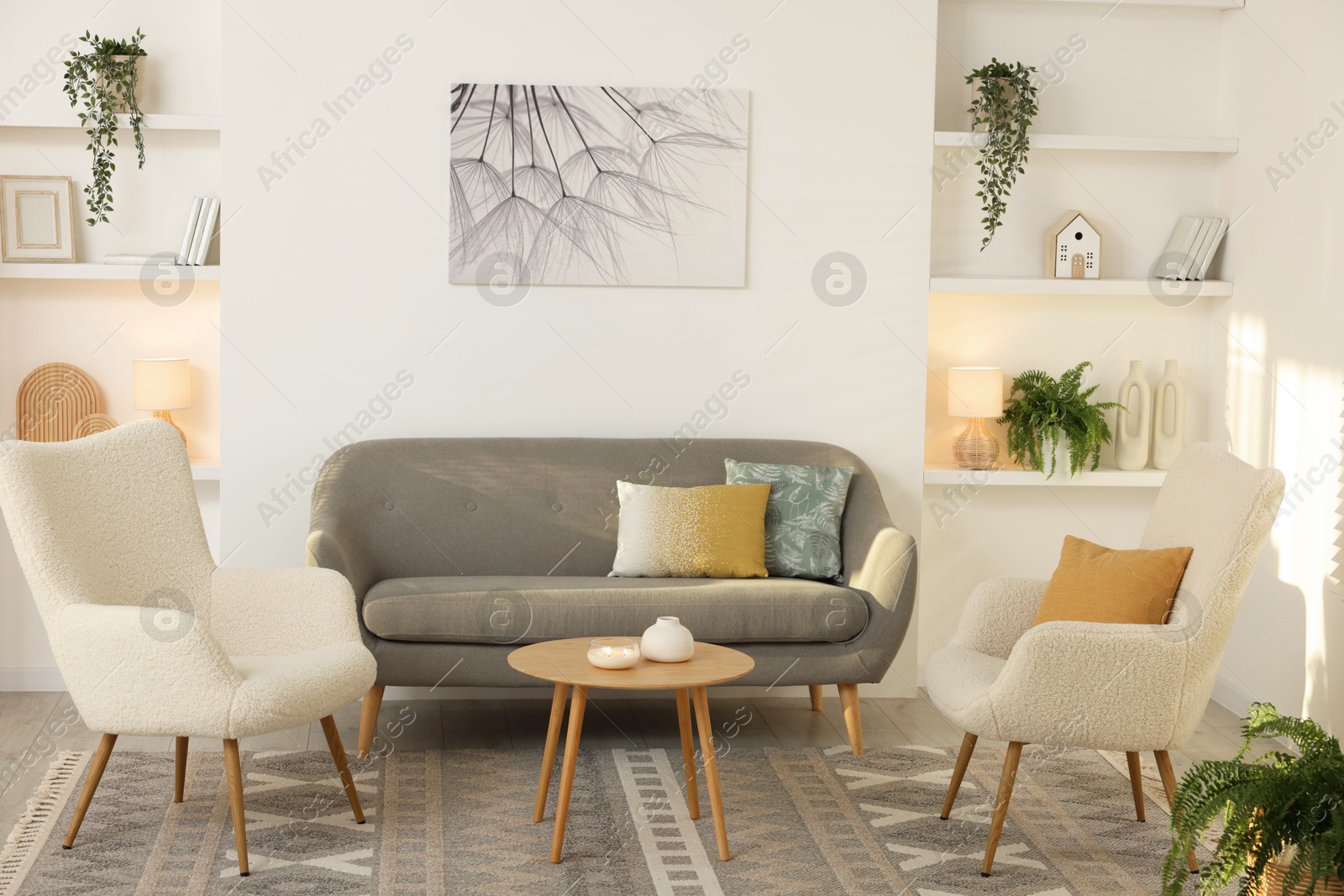 Photo of Beautiful armchairs, sofa and coffee table in living room. Interior design