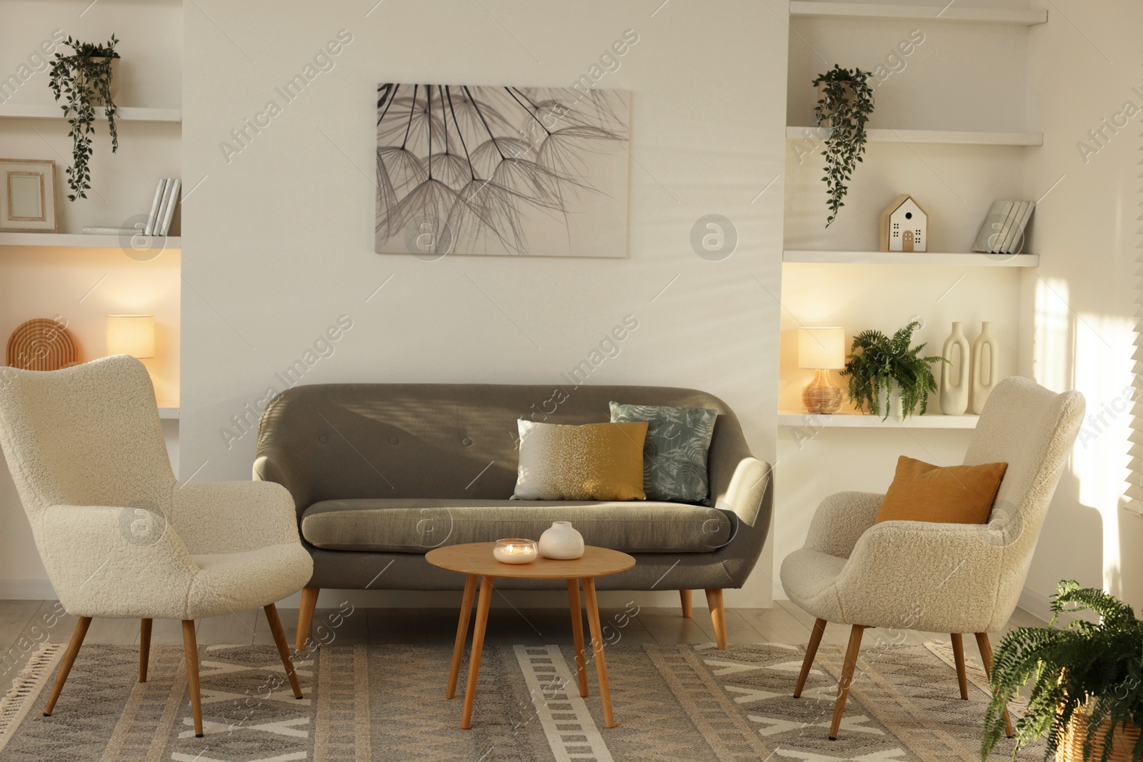 Photo of Beautiful armchairs, sofa and coffee table in living room. Interior design