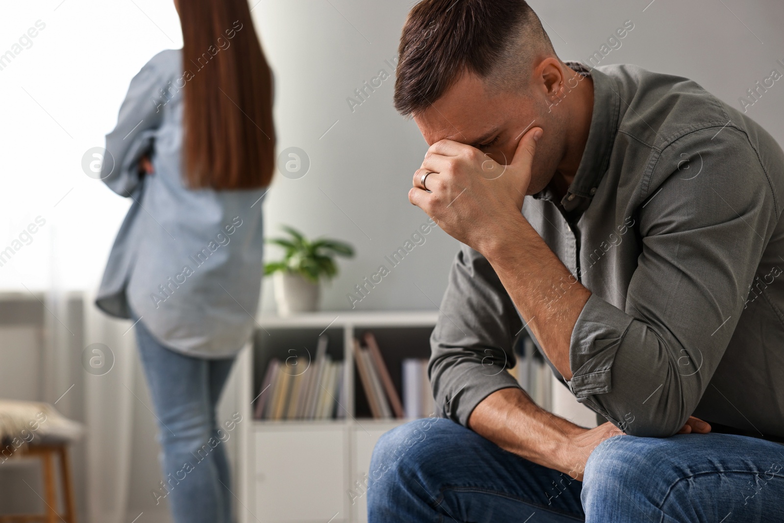 Photo of Offended couple ignoring each other at home, selective focus