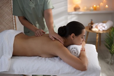 Photo of Young woman receiving massage in spa salon