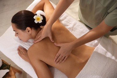 Photo of Woman receiving back massage in spa salon, top view