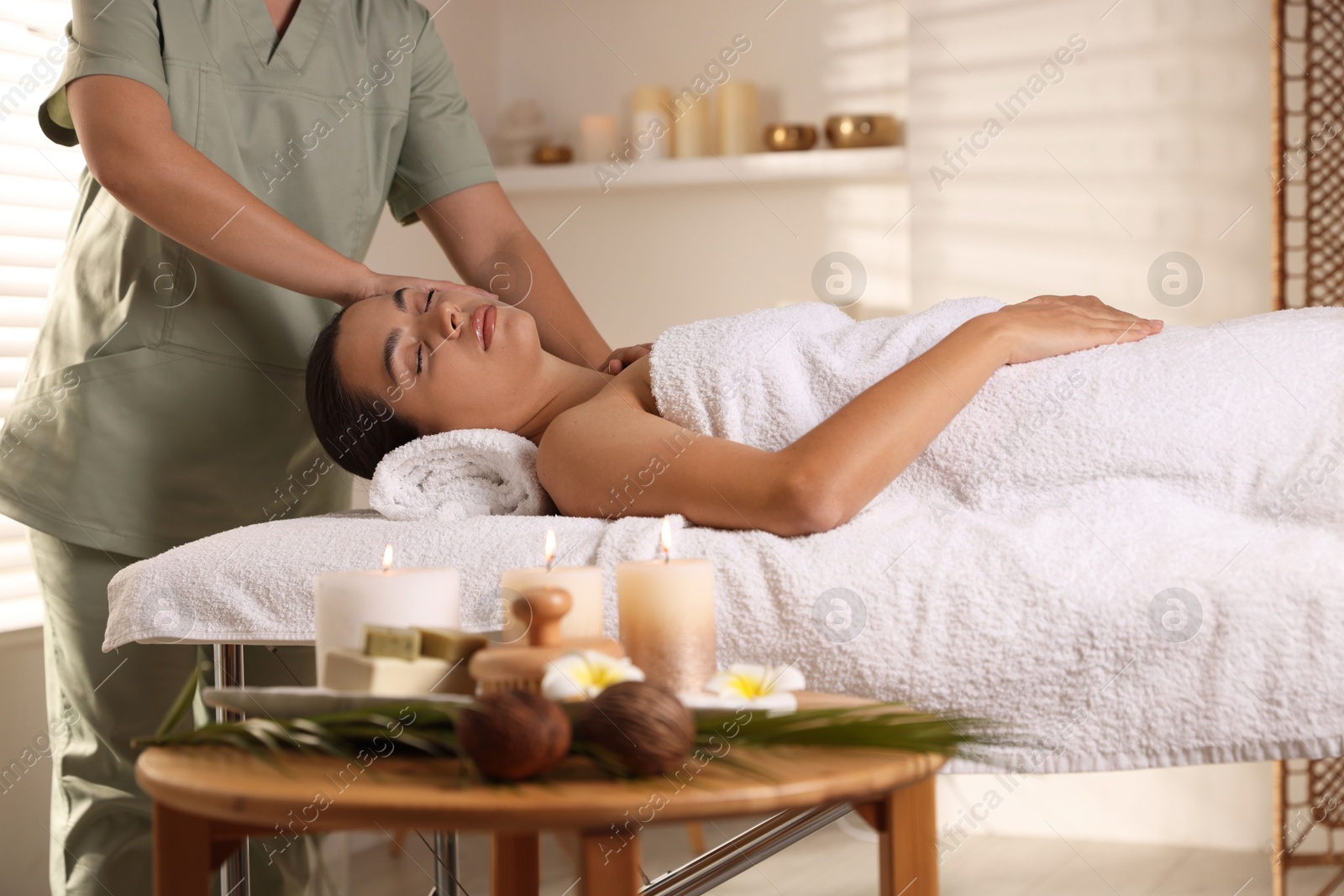 Photo of Young woman receiving massage in spa salon