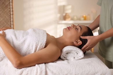 Photo of Young woman receiving massage in spa salon