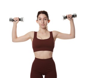 Woman in sportswear exercising with dumbbells on white background