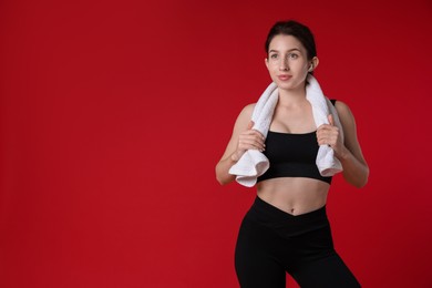 Photo of Woman in sportswear with towel on red background, space for text