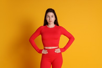 Photo of Portrait of woman in sportswear on orange background