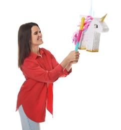 Photo of Happy woman hitting unicorn shaped pinata with stick on white background