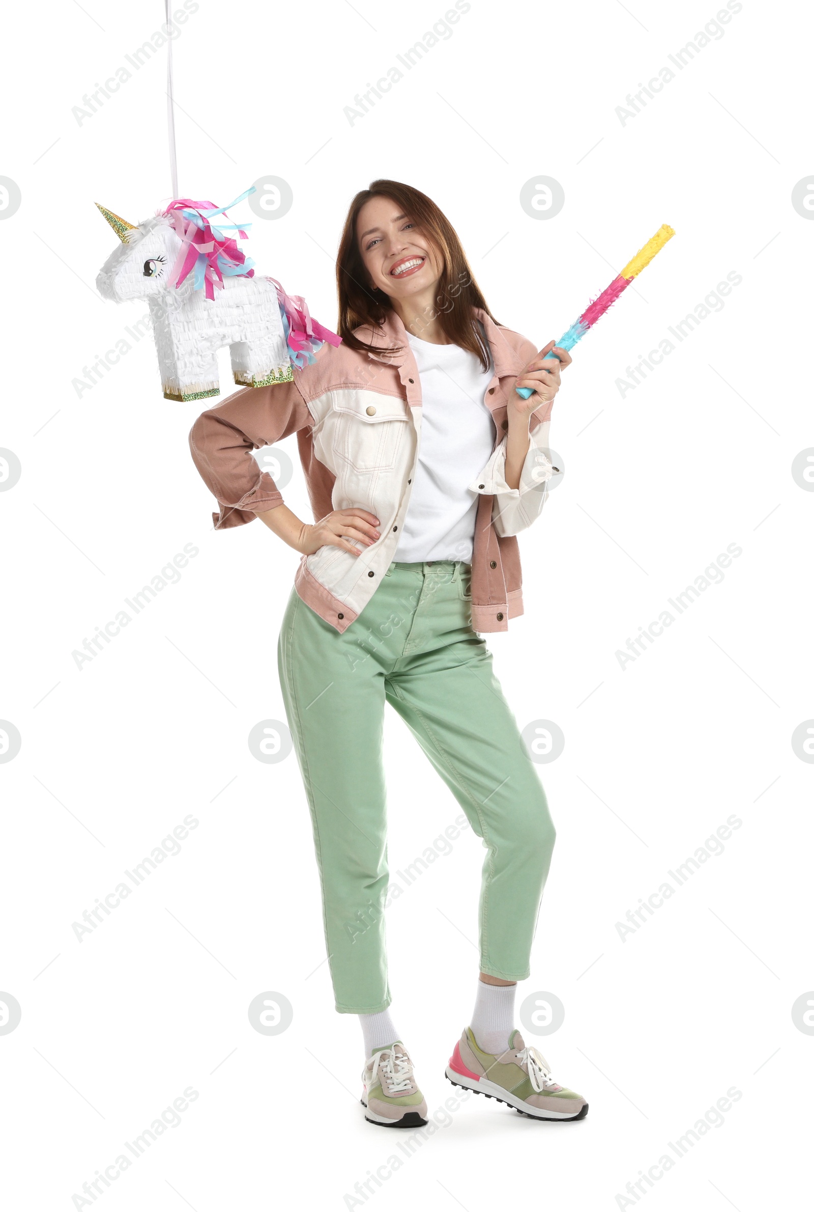 Photo of Happy woman with unicorn shaped pinata and stick isolated on white